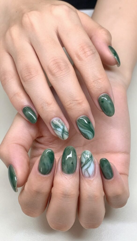 Olive green marble nails on medium almond-shaped nails with soft white and gray veins