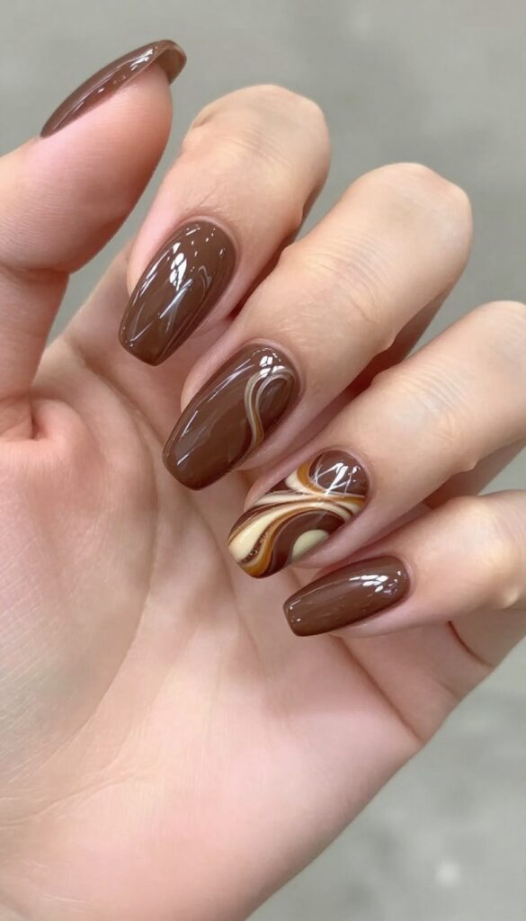 Chocolate swirl nails with caramel and cream swirls on a glossy brown base