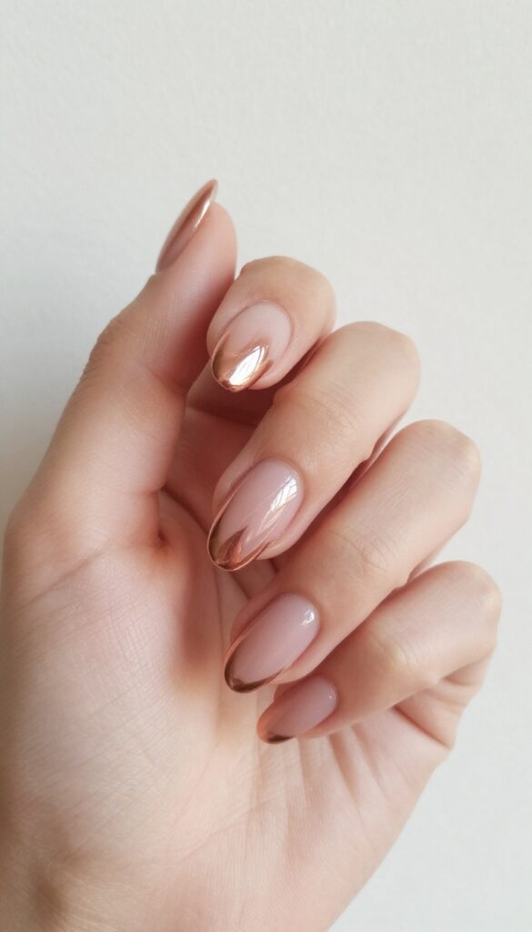 Rose gold chrome nails with negative space on almond-shaped nails