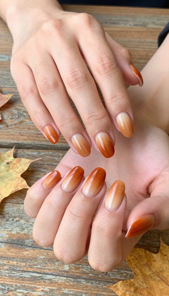 Classic pumpkin spice ombré dip powder nails with burnt orange to nude gradient and glossy finish