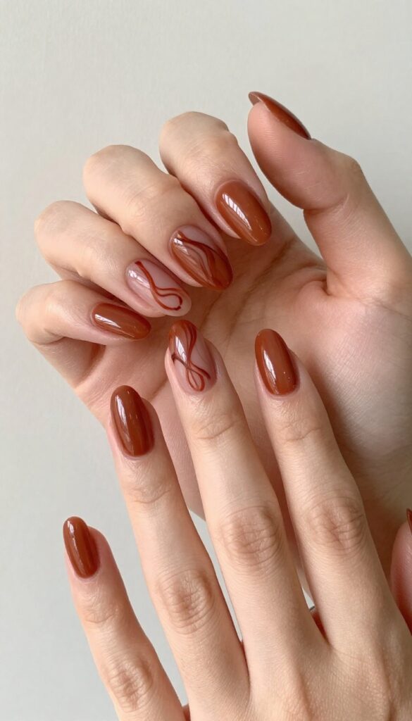 Burnt sienna gel nails with hand-painted rust swirls, glossy finish, almond shape