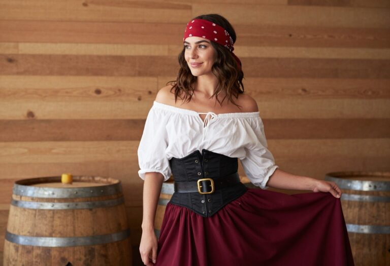 Woman wearing a modern pirate costume with a white blouse, black corset, and burgundy skirt, standing in a casual pose.