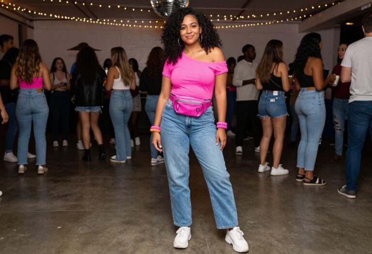 Woman in 80s neon outfit with fanny pack and chunky sneakers at a party
